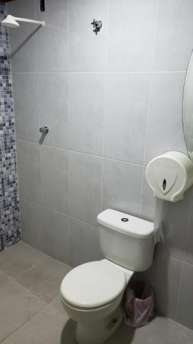 a bathroom with a white toilet and a sink at Hotel Opção in Manaus