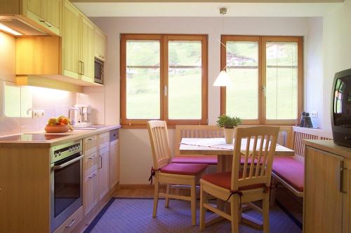 a kitchen with a table and chairs and a dining room at Biotel Bertel Naturappartements in Brand