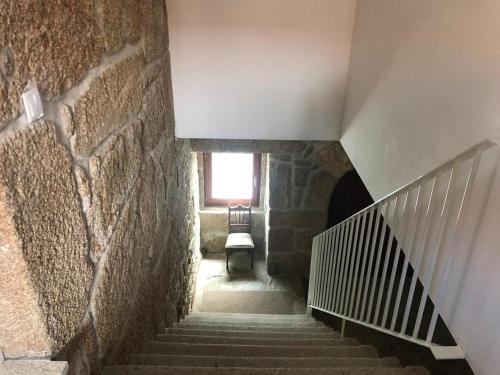 a staircase in a building with a window and a chair at ZN Lodge in Vidago