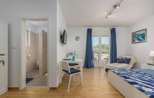 1 dormitorio con cama, escritorio y baño en Apartment Complex Jelena, en Funtana