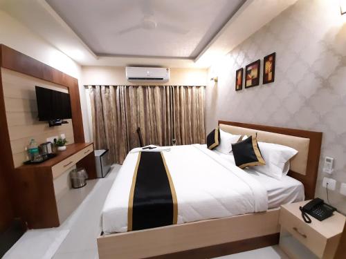 a bedroom with a large bed and a television at Liza Regency in Chennai