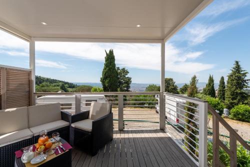 a deck with chairs and a table on a balcony at Camping Village Panoramico Fiesole in Fiesole