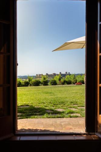 a window looking out at a field of grass at Borgo dé Brandi in Monteriggioni