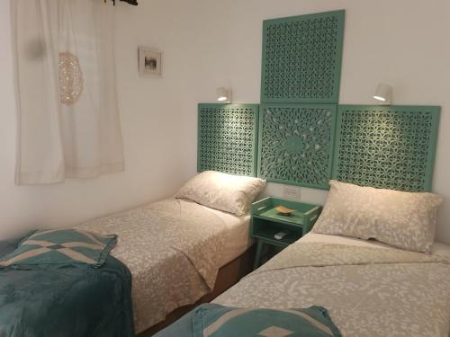 ハイファにあるThe Potter's House overlooking the Bay of Haifaの緑と白の部屋のベッド2台