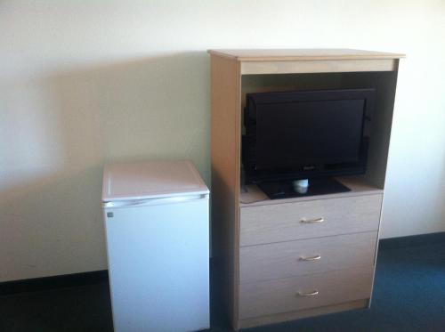 a small refrigerator and a television in a cabinet at Crown Inn in Seattle