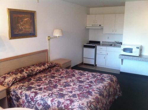 a hotel room with a bed and a kitchen at Crown Inn in Seattle