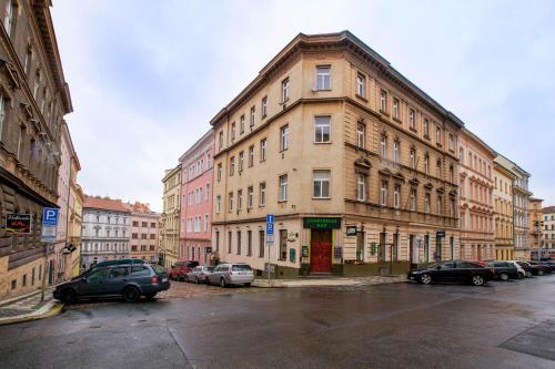 un gran edificio con coches estacionados en un estacionamiento en Žižkov Cosy Studio Apartments en Praga