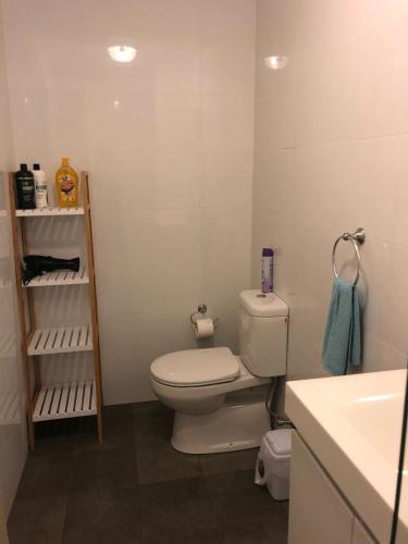 a bathroom with a white toilet and a sink at Modern Apartment in Liverpool CBD in Liverpool