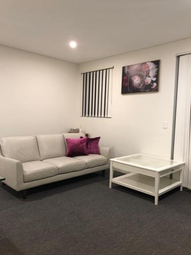 a living room with a white couch and a table at Modern Apartment in Liverpool CBD in Liverpool