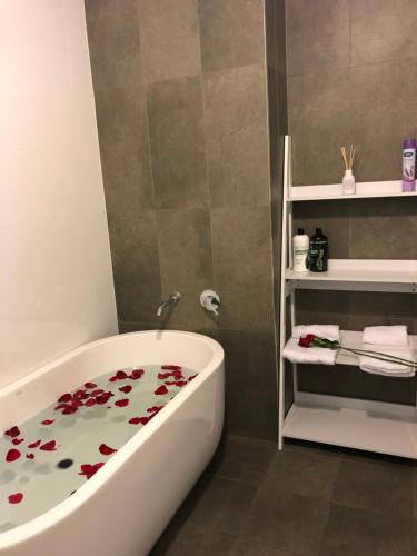 a bathroom with a bath tub with flowers on the floor at Modern Apartment in Liverpool CBD in Liverpool