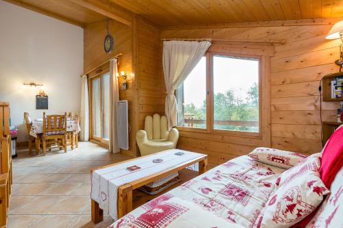 a living room of a log cabin with a bed and a table at Apartment Le Kandahar in Les Houches