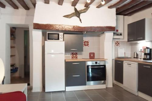 uma cozinha com um frigorífico e um fogão forno superior em GITE LE PETIT VAUCHEL A 3,5 KM D'ETRETAT em Pierrefiques