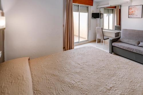 サロウにあるホテル ニザのベッドルーム1室(ベッド1台、ソファ、デスク付)