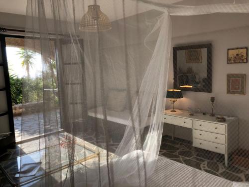 a bedroom with a bed with a mosquito net at SEA BREEZE STUDIO in Loutraki