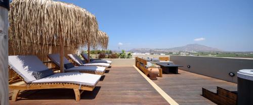 a row of chaise lounges on a roof at Misteli Suites in Akrotiri