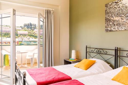 ein Schlafzimmer mit einem Bett und einem Balkon in der Unterkunft Hotel Mimosa in Sidari