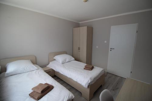 a bedroom with two beds with towels on them at Pod Kominem Pokoje i Apartamenty in Brzezie