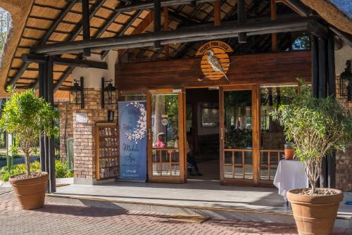 a building with an open door with potted plants at Kruger Park Lodge Unit No. 277 in Hazyview