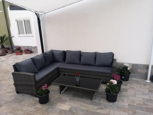 a couch and a table in a patio with flowers at MIRA B&B in Campiano