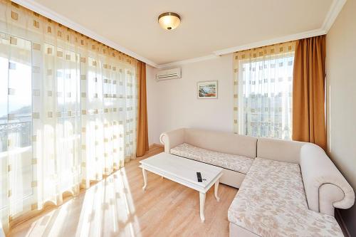 a living room with a couch and a table at Penelopa Palace Apart Hotel & SPA in Pomorie