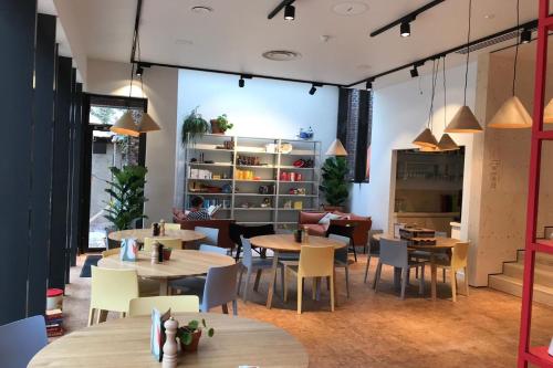 a restaurant with tables and chairs in a room at The Green Elephant Hostel & Spa in Maastricht