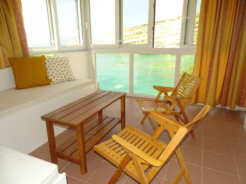 sala de estar con 2 sillas y mesa en Beach View Matala, en Matala