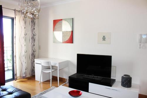 a white living room with a tv and a desk at MCStylo-Residenza in Funchal