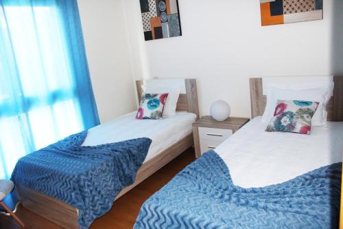 a bedroom with two beds with blue blankets on them at MCStylo-Residenza in Funchal