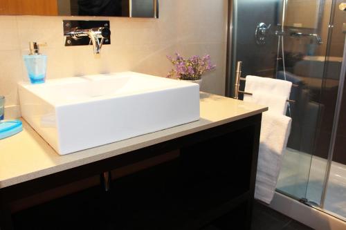 a bathroom with a white sink and a shower at MCStylo-Residenza in Funchal