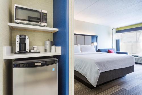 a hotel room with a bed and a microwave at Holiday Inn Express - Lorton, an IHG Hotel in Lorton