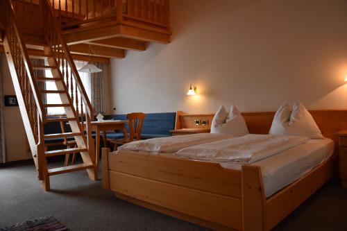 a bedroom with a bed with a wooden ladder at Garni Haus Tyrol in Corvara in Badia