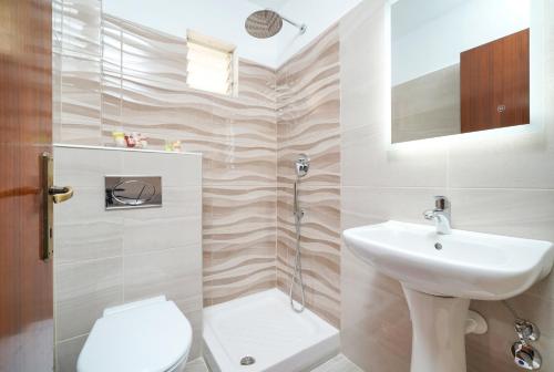ein Badezimmer mit Waschbecken, Toilette und Dusche in der Unterkunft Studios Panagiota in Potos