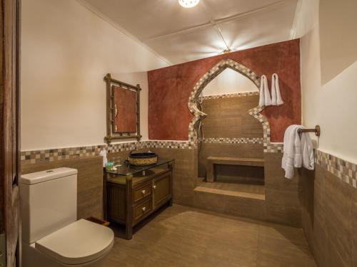 ein Badezimmer mit einem WC, einem Waschbecken und einem Spiegel in der Unterkunft Beyt Al Salaam in Zanzibar City