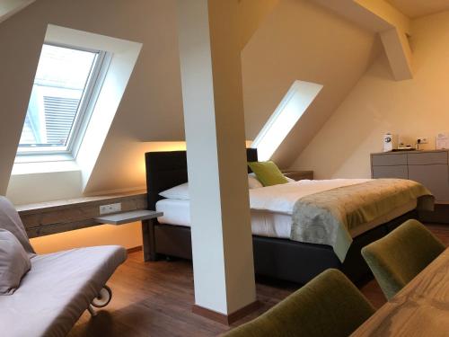two beds in a room with two windows at Hotel Braun in Voitsberg