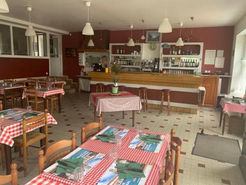 un restaurante con mesas y sillas y un bar en Auberge du Mont Tortue, en Champclause