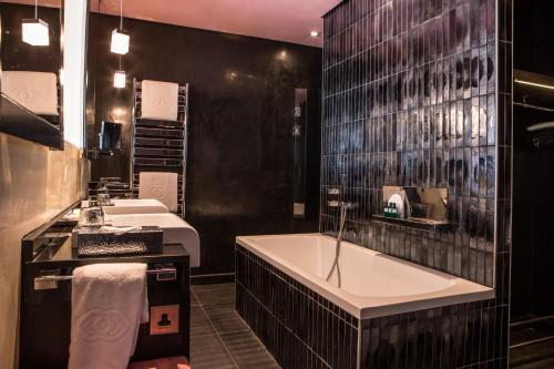 a bathroom with two sinks and a bath tub at Sofitel Casablanca Tour Blanche in Casablanca