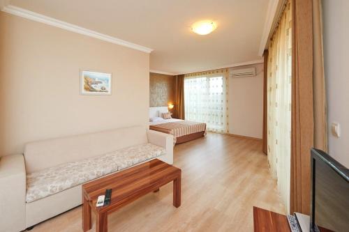 a room with a couch and a bed and a table at Penelopa Palace Apart Hotel & SPA in Pomorie