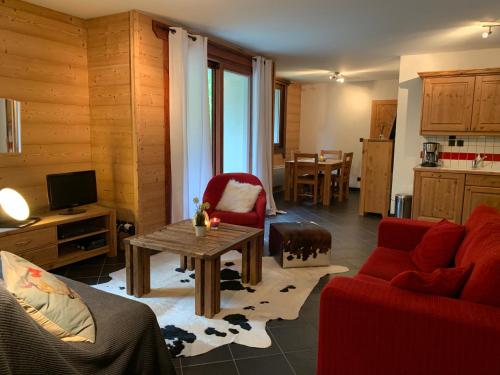 a living room with a red couch and a table at Residence le Paradis in Chamonix-Mont-Blanc
