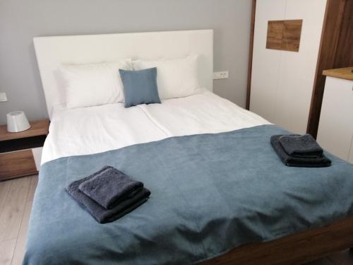 a bedroom with a large bed with two towels on it at Apartments Lapidarium in Ohrid