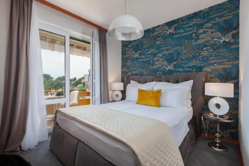 ein Schlafzimmer mit einem großen Bett mit blauer Wand in der Unterkunft Apartments Il Giardino in Makarska