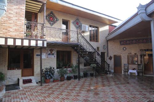 a brick building with a staircase and potted plants at Sherxan House in Samarkand