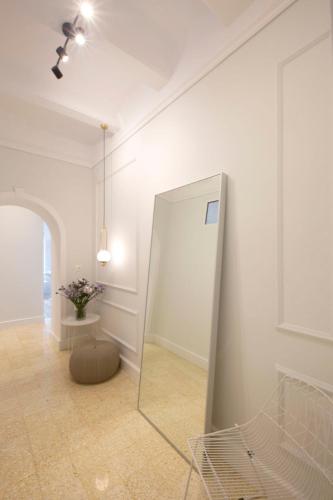 a mirror in a white room with a vase of flowers at Glyfada Villa 6BR 16ppl Private Pool 300m to Beach in Athens