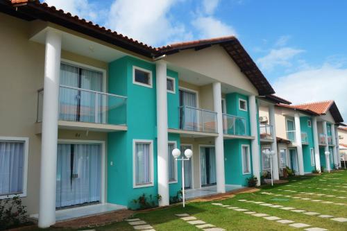 a row of houses with green and white at Residencial Mont Moria - Tonziro in Porto Seguro