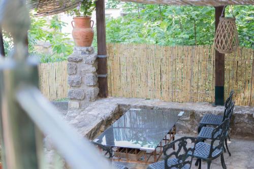 eine Terrasse mit einem Tisch, Stühlen und einem Zaun in der Unterkunft Hostal Caseria San José de Hutar in Hútar