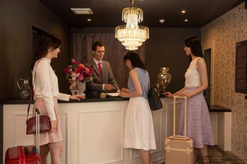 a group of people standing around a bar with luggage at Framboise KYOTO Hotel de charme in Kyoto
