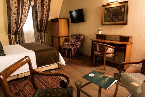 布宜諾斯艾利斯的住宿－五月花套房酒店，配有一张床和一张书桌的酒店客房
