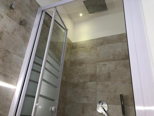 y baño con ducha y puerta de cristal. en Casa Vacanze Aria Salentina, en Torre Pali