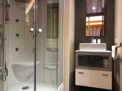 a bathroom with a shower and a sink and a toilet at Hostal Piteus in Sant Llorenc de Morunys