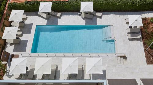 uma vista sobre uma piscina com cadeiras brancas em Nuria em Tarragona