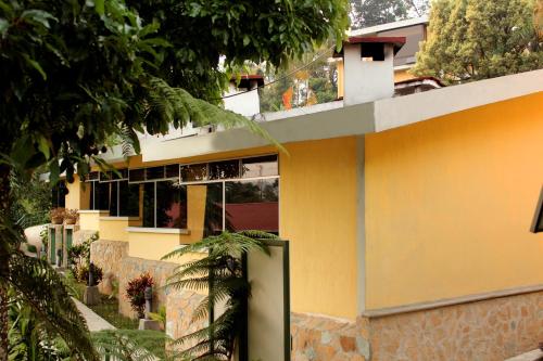 a yellow house with a green door in front of it at Park Hotel in Santa Cruz Verapaz